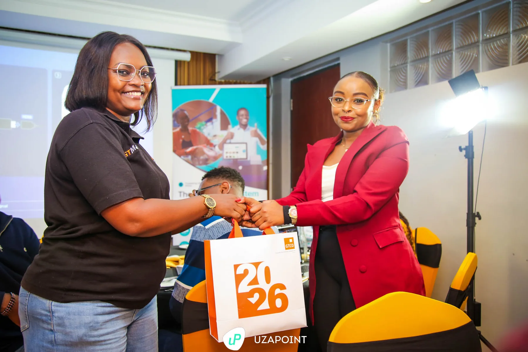 Partners exchanging a recognition gift at an Uzapoint event